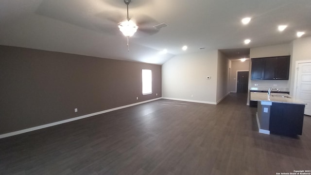 unfurnished living room featuring lofted ceiling, sink, and dark wood-type flooring