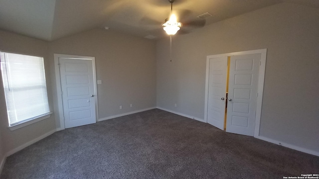 empty room featuring lofted ceiling and dark carpet