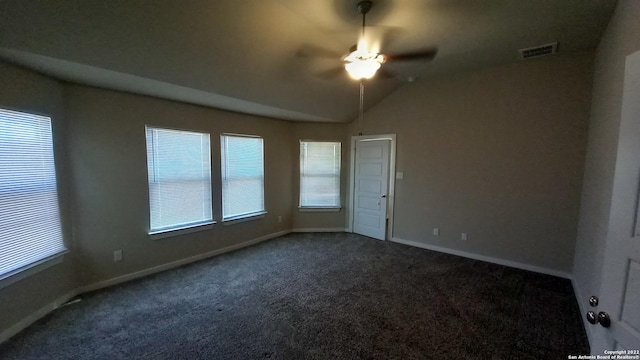 unfurnished room featuring lofted ceiling, a wealth of natural light, carpet floors, and ceiling fan