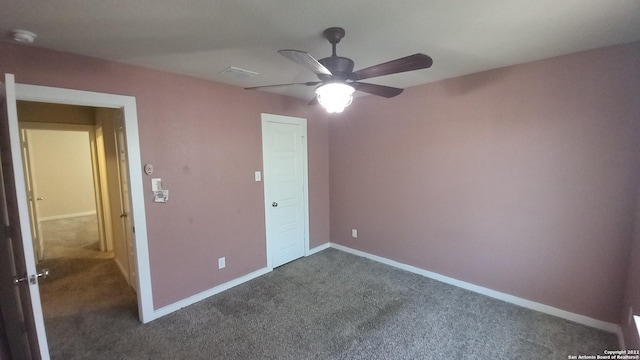 unfurnished bedroom with dark carpet and ceiling fan