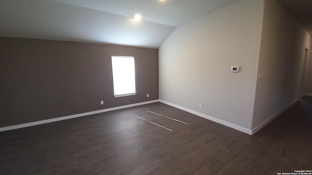 unfurnished room with dark hardwood / wood-style flooring and vaulted ceiling