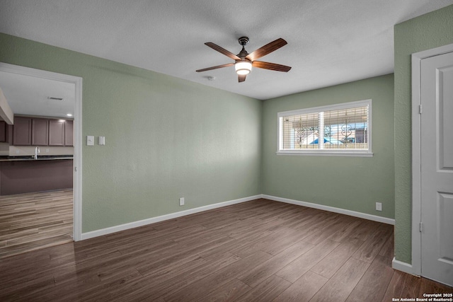 spare room featuring sink, hardwood / wood-style flooring, and ceiling fan