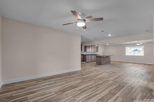 unfurnished living room featuring light hardwood / wood-style flooring and ceiling fan