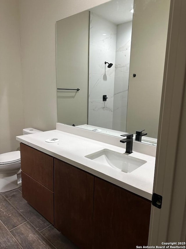 bathroom featuring vanity, a shower, and toilet