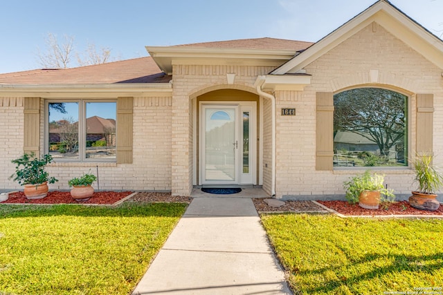 property entrance featuring a lawn