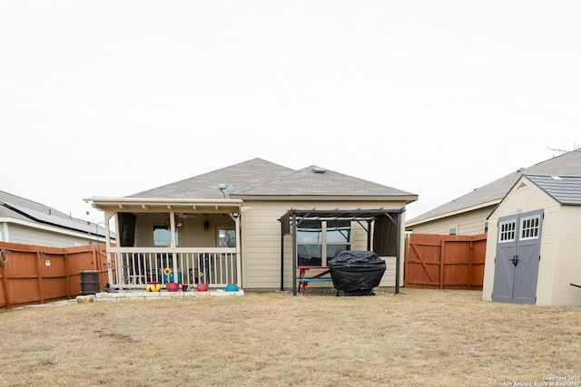 rear view of house with a storage shed and a lawn