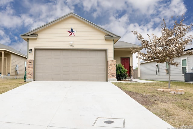 view of front of home featuring a garage, central AC unit, and a front yard