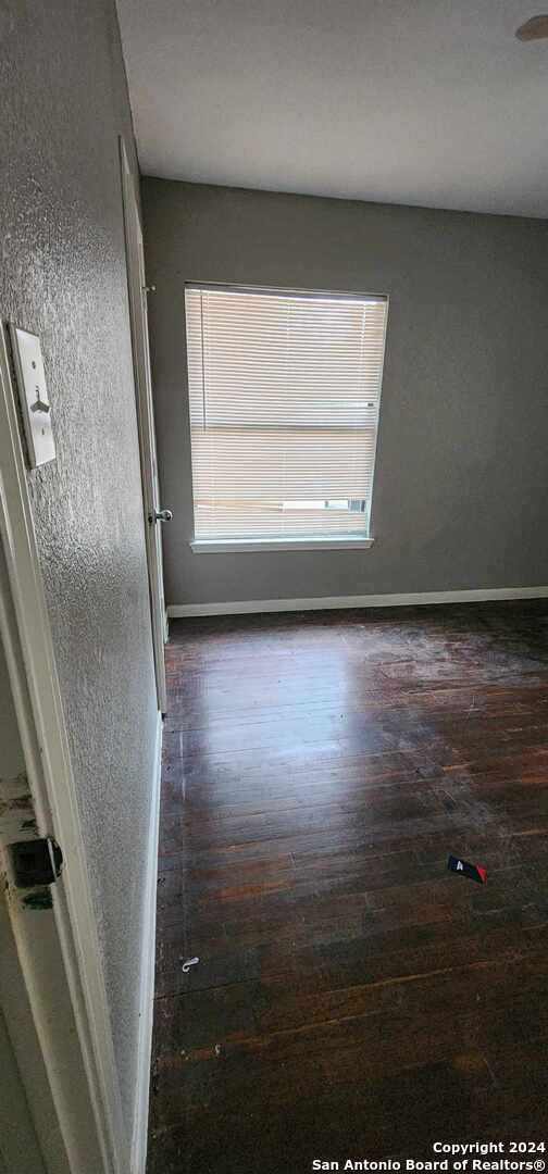 spare room with dark wood-type flooring