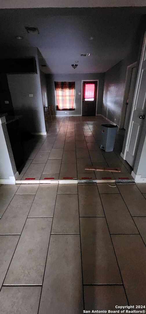 hall with tile patterned floors