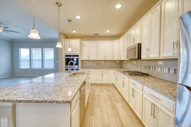 kitchen featuring tasteful backsplash, an island with sink, appliances with stainless steel finishes, and sink