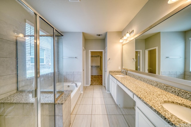 bathroom with vanity, plenty of natural light, tile patterned floors, and plus walk in shower