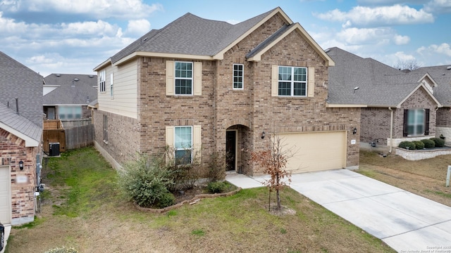 view of front of property featuring cooling unit, a garage, and a front lawn