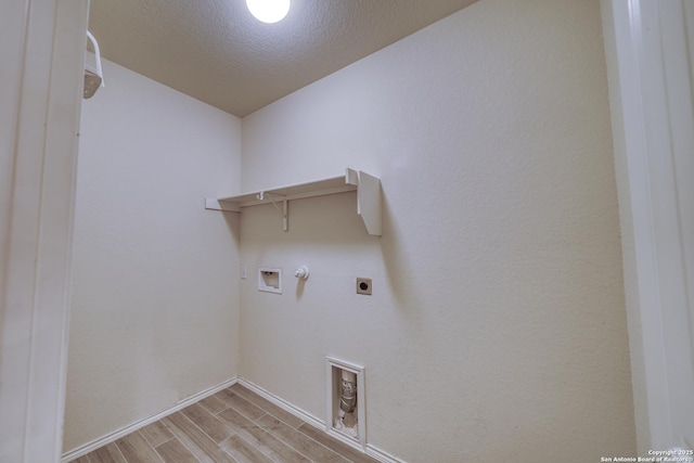 laundry room with hookup for a washing machine, light hardwood / wood-style floors, a textured ceiling, hookup for a gas dryer, and hookup for an electric dryer