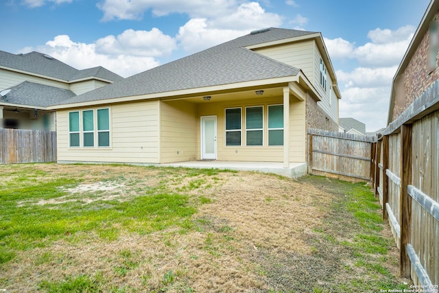 rear view of house featuring a yard and a patio area