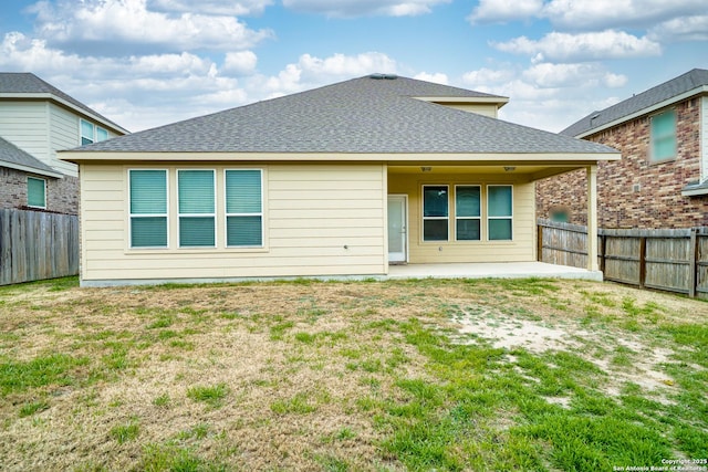 back of property featuring a patio and a lawn