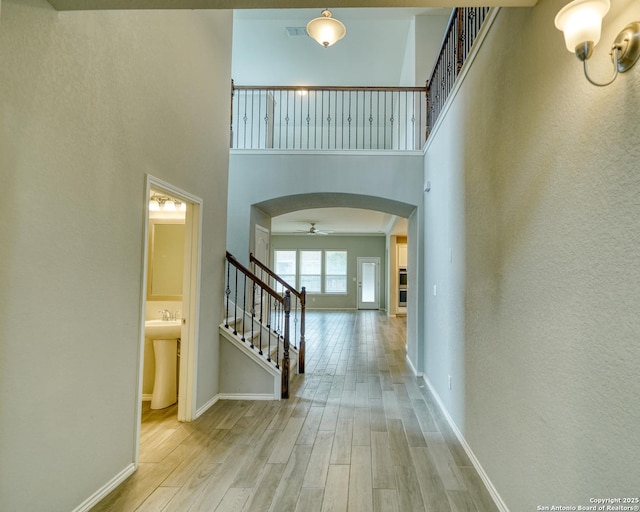 entrance foyer featuring sink, light hardwood / wood-style floors, and a high ceiling