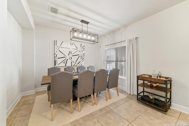 dining space featuring light tile patterned floors and a notable chandelier