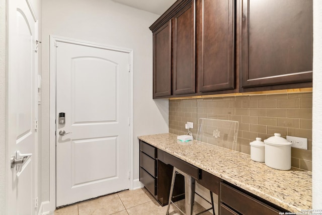 clothes washing area featuring light tile patterned floors