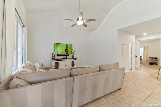 tiled living room with ceiling fan and vaulted ceiling