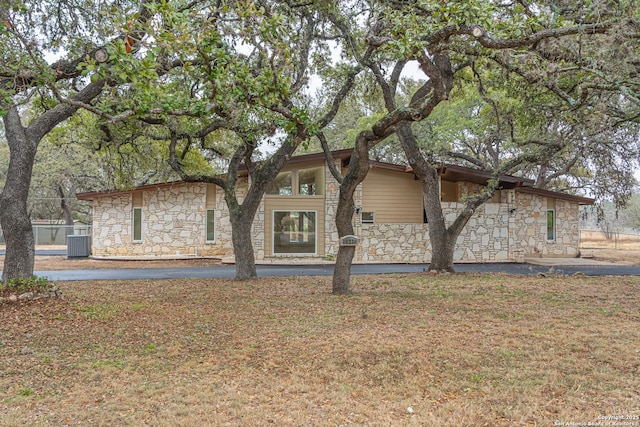 view of front of property with a front lawn and central air condition unit