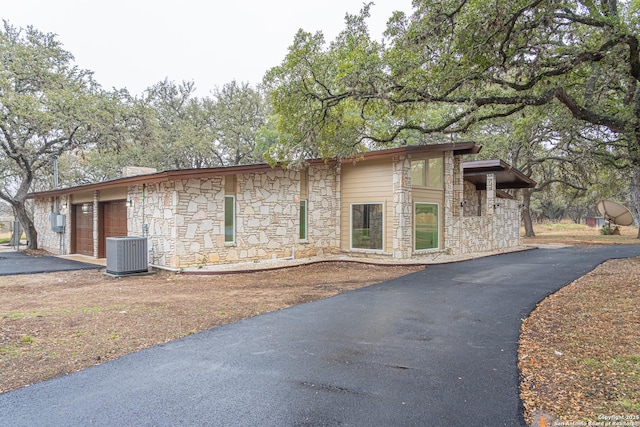 view of property exterior with a garage and central AC