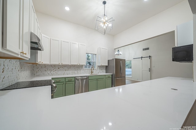 kitchen with appliances with stainless steel finishes, sink, white cabinets, hanging light fixtures, and green cabinets