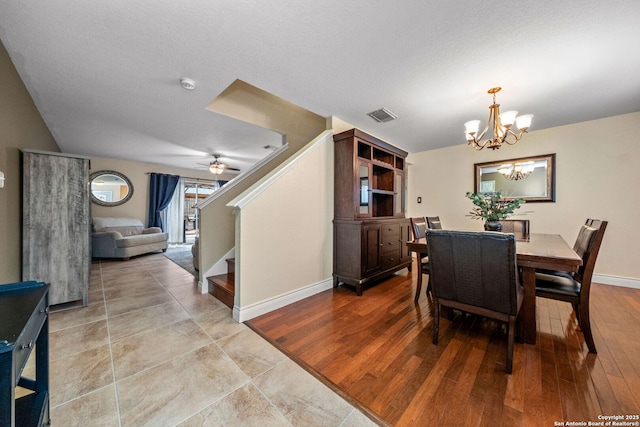 dining area with ceiling fan with notable chandelier, light hardwood / wood-style floors, and a textured ceiling