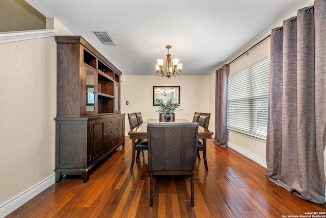 dining space featuring an inviting chandelier and dark wood-type flooring