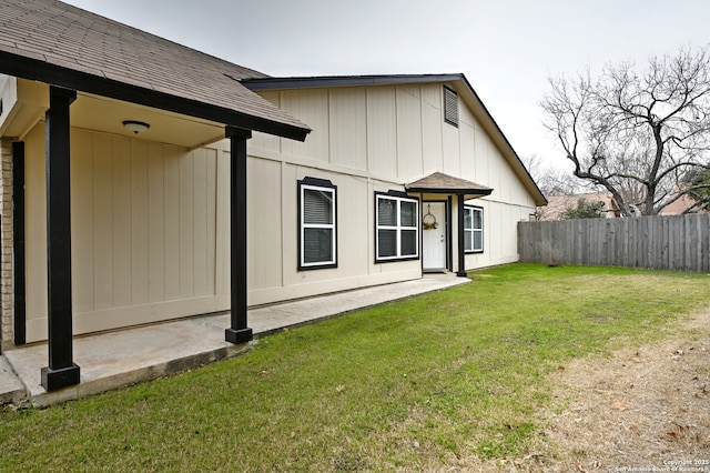 rear view of house featuring a lawn and a patio area