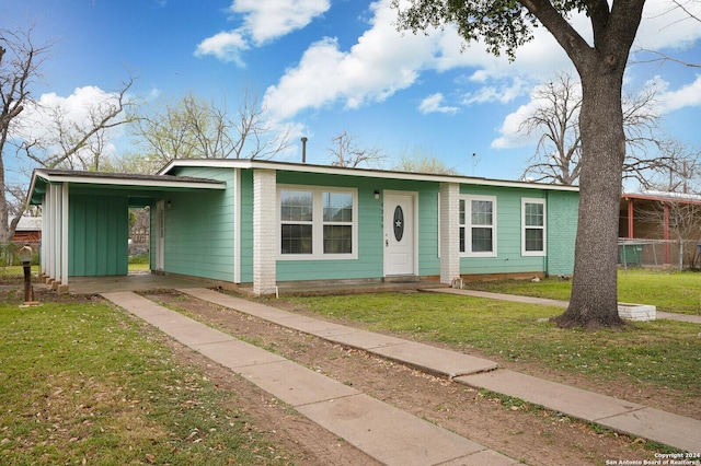 ranch-style home featuring a carport and a front lawn