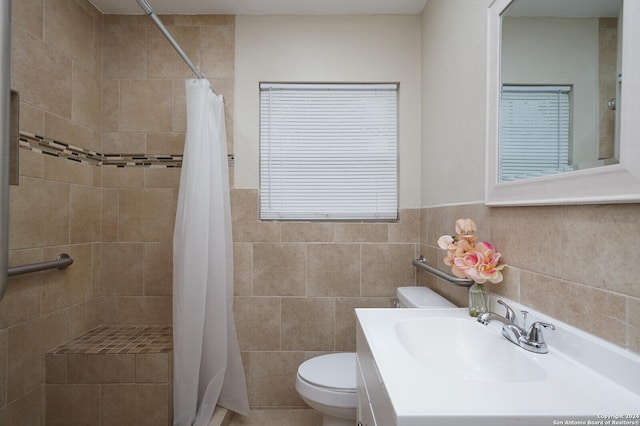 bathroom featuring toilet, tile walls, vanity, and walk in shower