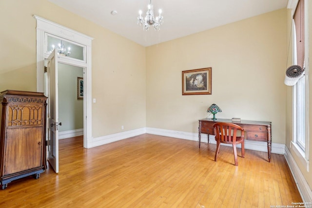 office featuring a chandelier, light wood-style flooring, and baseboards