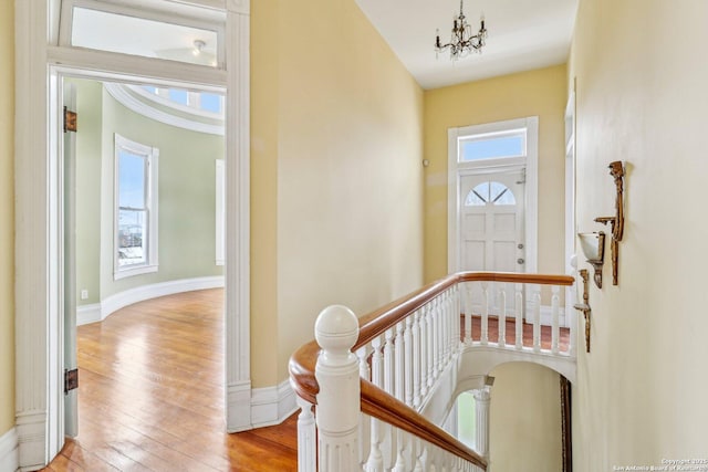 entryway with a chandelier, wood-type flooring, and baseboards