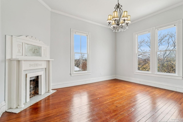 unfurnished living room with baseboards, a fireplace with flush hearth, ornamental molding, and hardwood / wood-style floors