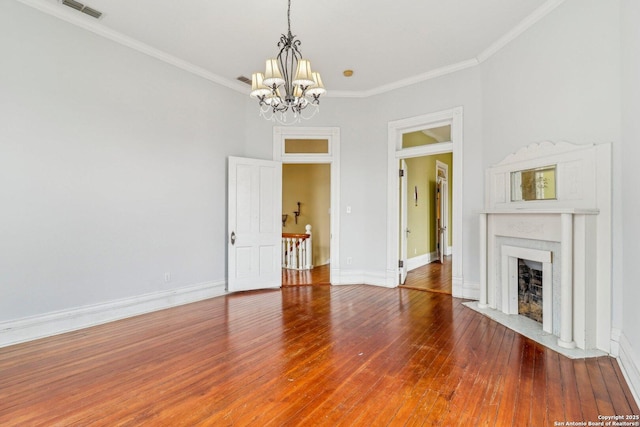 unfurnished living room with hardwood / wood-style flooring, a fireplace with flush hearth, visible vents, and crown molding