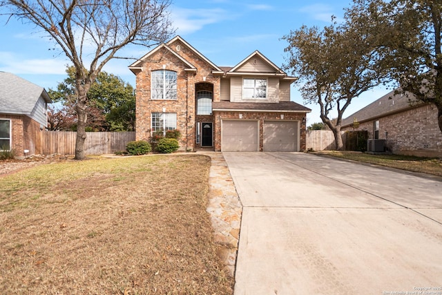 view of property with a garage, central AC, and a front lawn