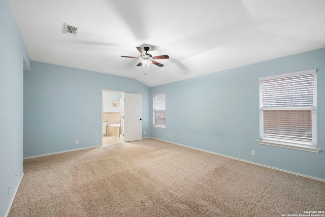 unfurnished bedroom featuring ensuite bath, vaulted ceiling, ceiling fan, and carpet