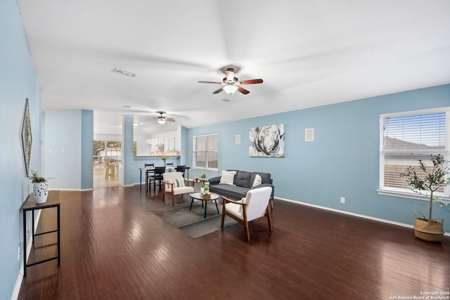 living room featuring ceiling fan and dark hardwood / wood-style flooring