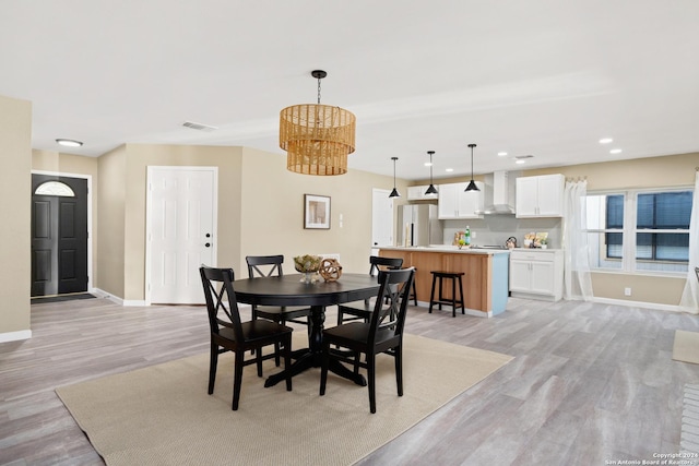 dining room featuring an inviting chandelier and light hardwood / wood-style flooring