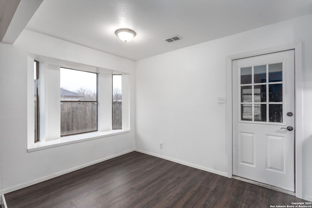 unfurnished room featuring dark hardwood / wood-style floors and a textured ceiling