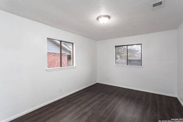 unfurnished room featuring dark hardwood / wood-style floors and a textured ceiling