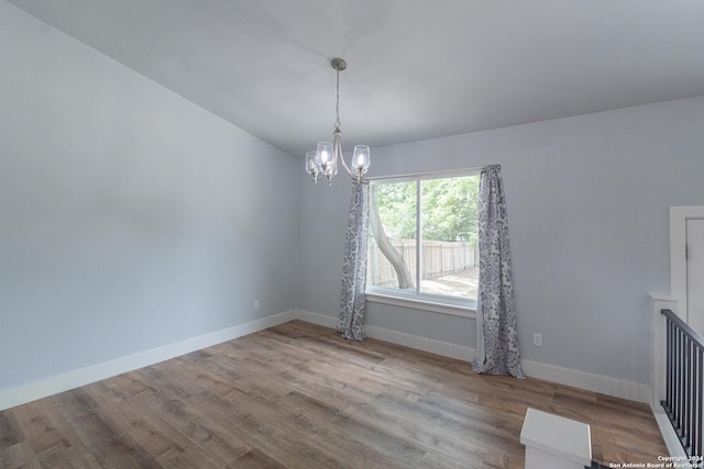 unfurnished dining area featuring a notable chandelier and light hardwood / wood-style floors