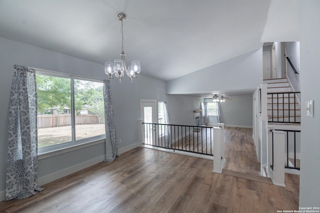 unfurnished dining area featuring wood-type flooring, vaulted ceiling, and a notable chandelier