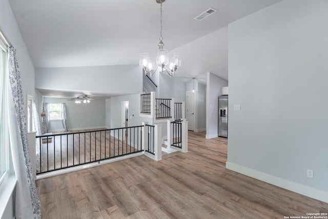 interior space with a notable chandelier, hardwood / wood-style flooring, and vaulted ceiling