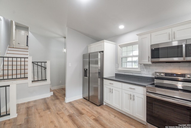 kitchen featuring white cabinetry, appliances with stainless steel finishes, light hardwood / wood-style floors, and decorative backsplash