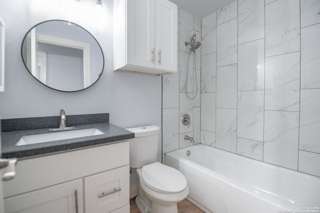 full bathroom with vanity, tiled shower / bath, and toilet