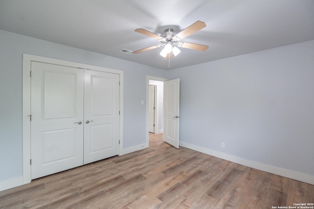 unfurnished bedroom featuring ceiling fan, a closet, and light wood-type flooring