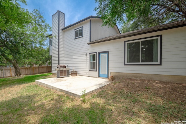 back of property with a yard and a patio area