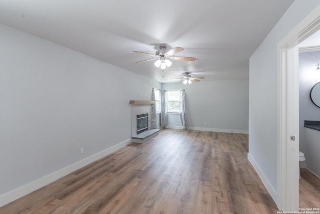 unfurnished living room with hardwood / wood-style flooring and ceiling fan