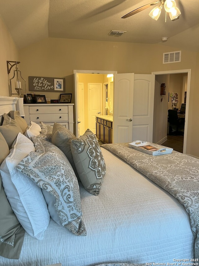 bedroom with ceiling fan, connected bathroom, and vaulted ceiling